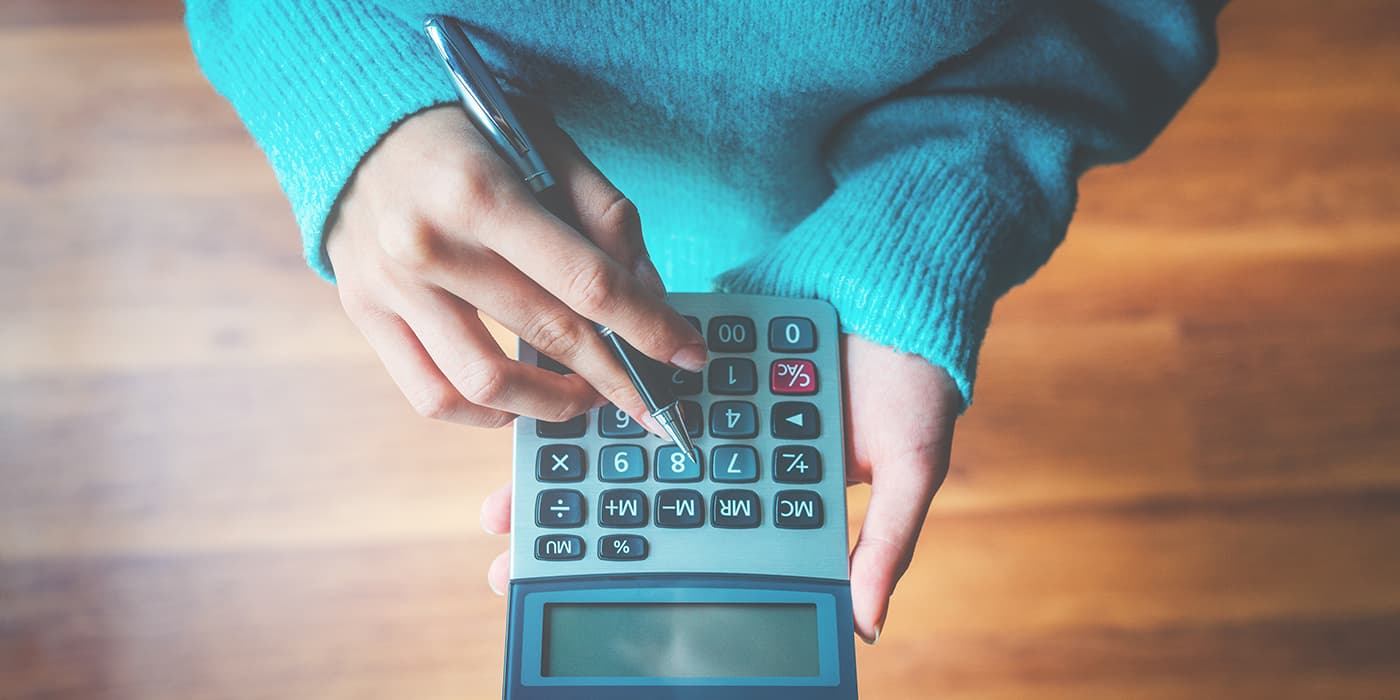 A top view of a person holding a calculator.